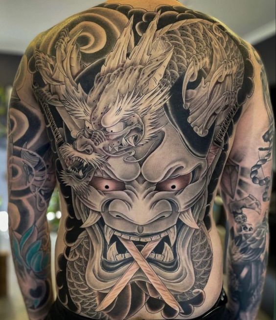 tattoo rồng kết hợp họa tiết mặt quỷ ngậm song kiếm bít lưng